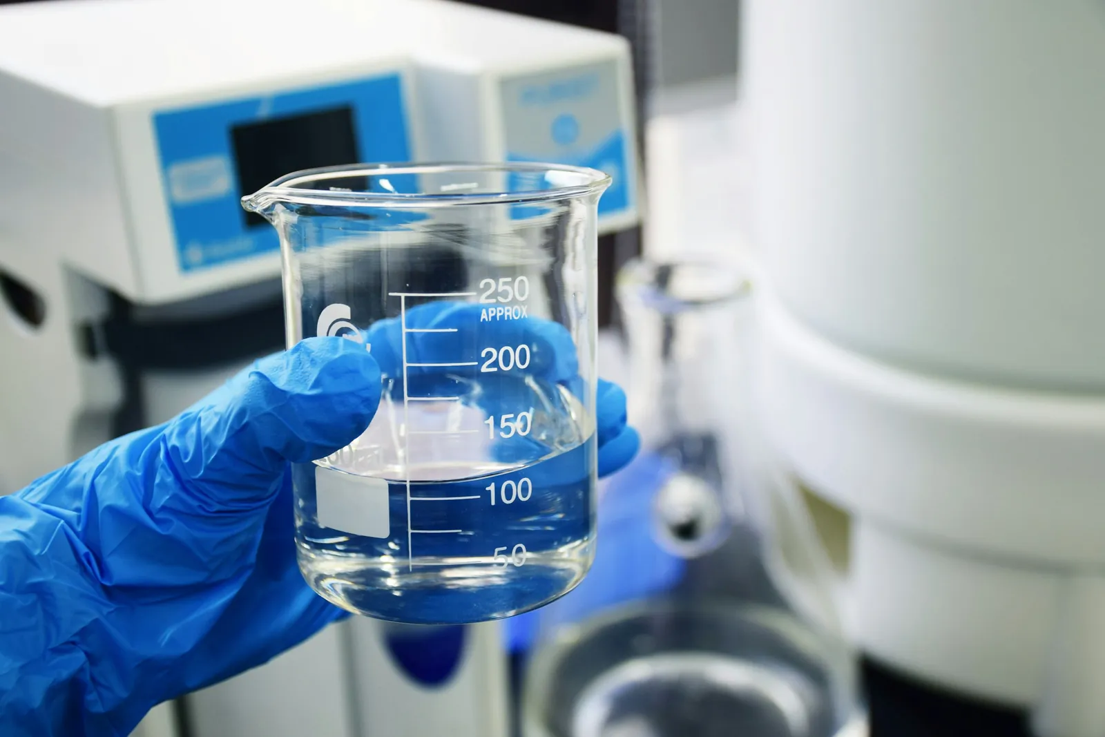 Laboratory technician holding a glass beaker for quality testing